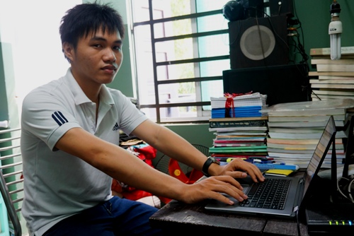 Phạm Phú Phong ngồi bên chiếc laptop trong góc học tập. Ảnh: Thạch Thảo.